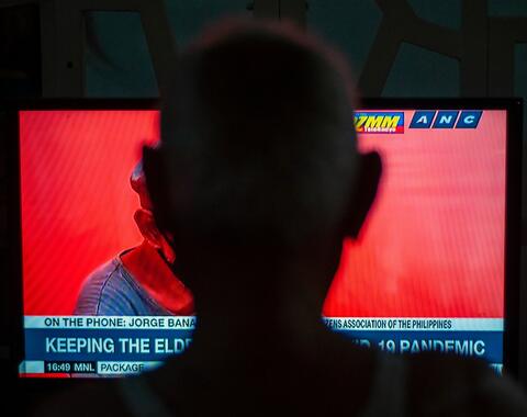 silhouette of head in front of a television screen