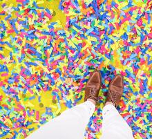 two feet on confetti-covered ground
