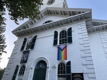 church building exterior with Black Lives Matter flag and Pride flag
